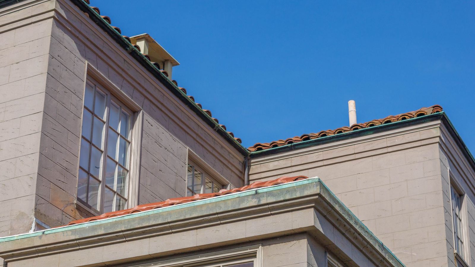 Gebäude mit Kupferdach und Dachgesims unter blauem Himmel